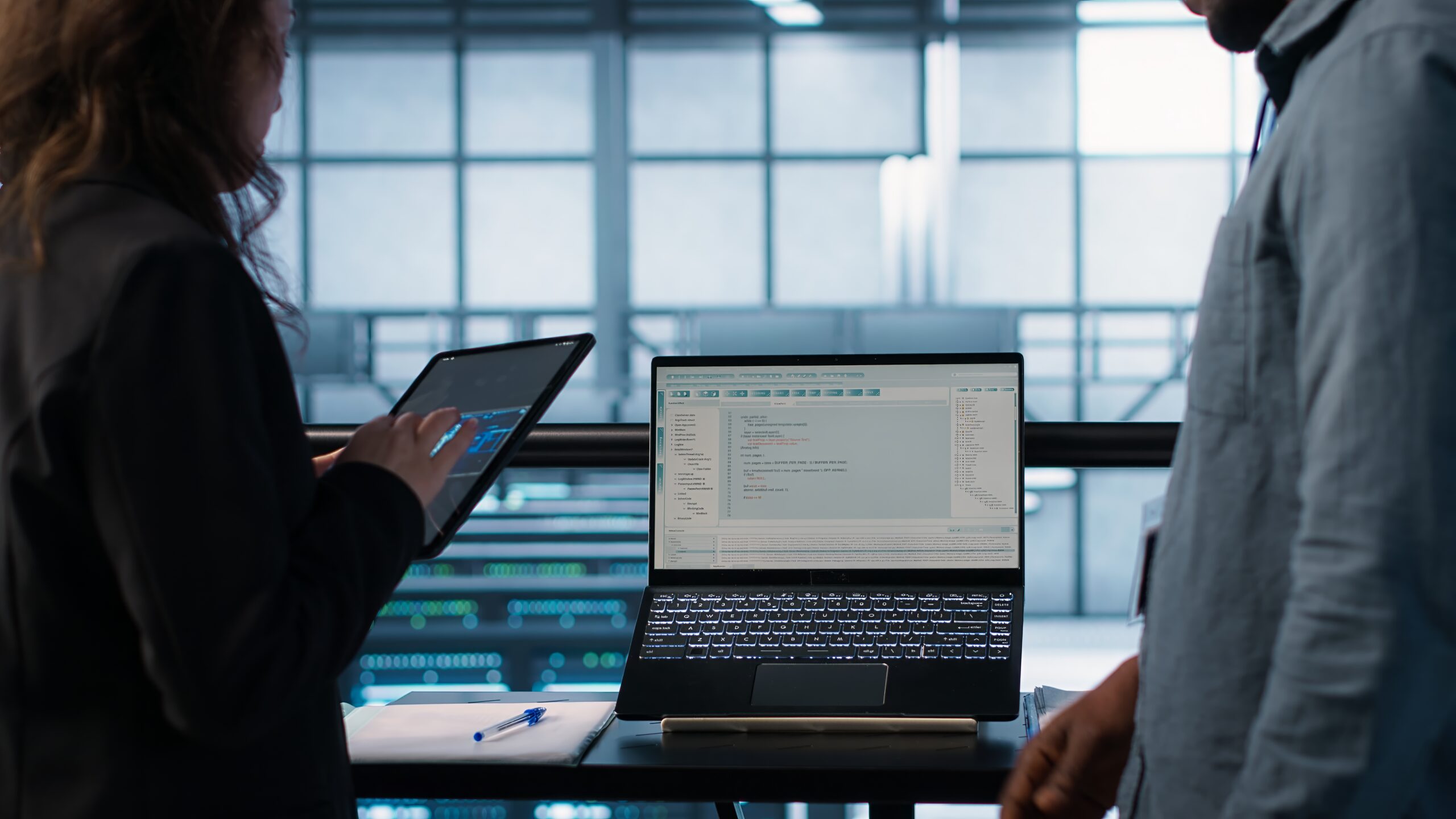 Programmers using AI technology on laptop and tablet in data center employing machine learning models. Devices used by artificial intelligence IT experts in server farm, camera A